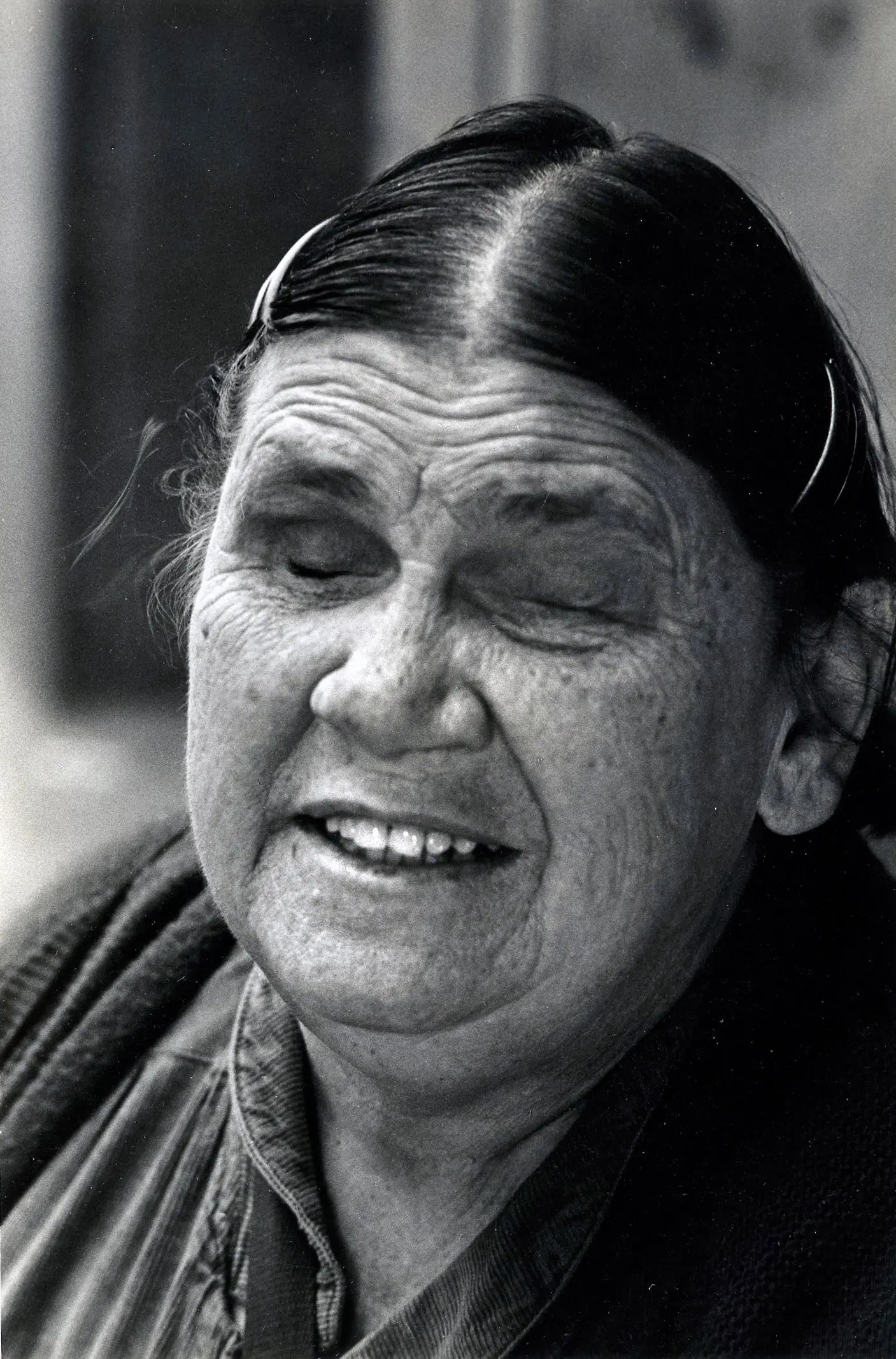 Smiling elderly woman with closed eyes.