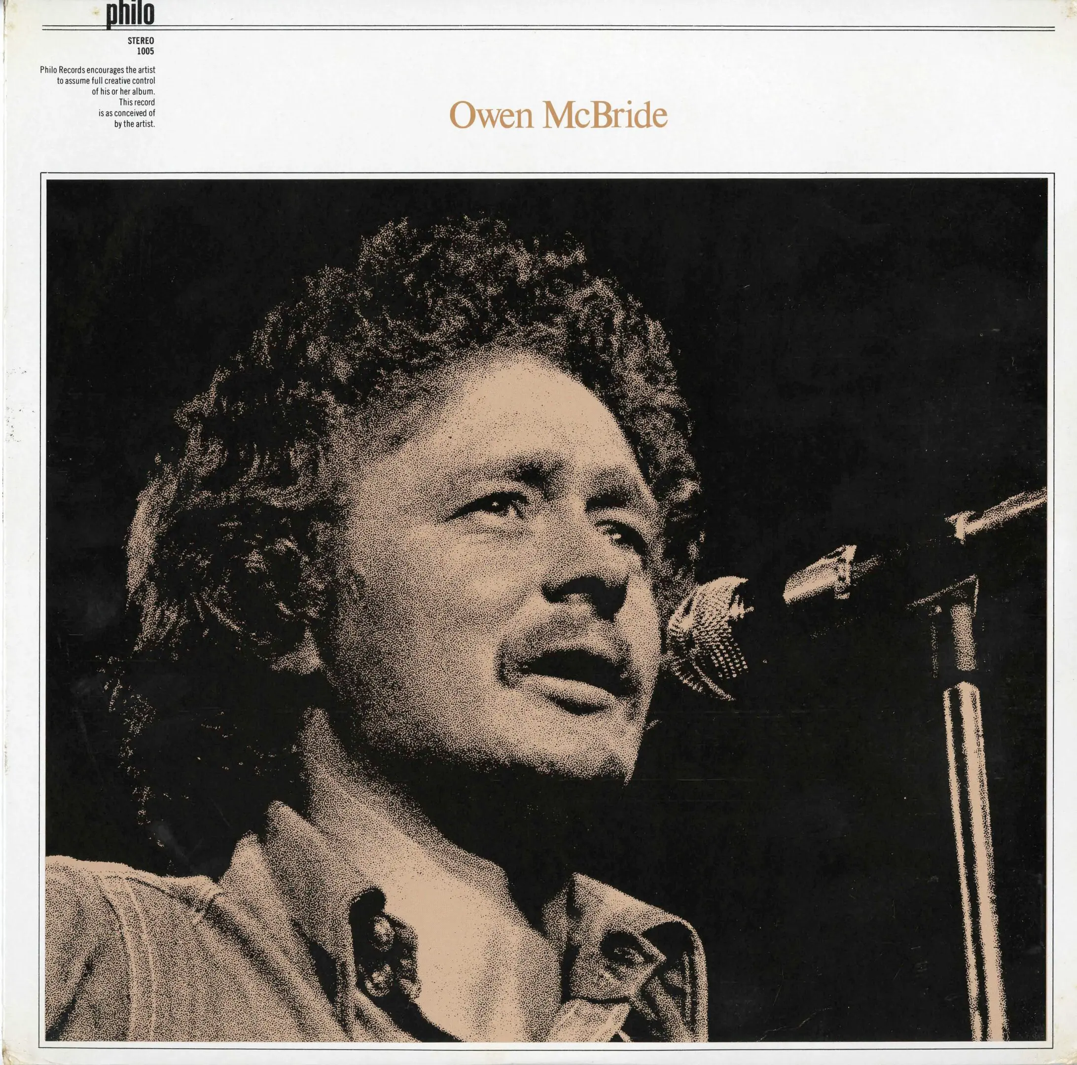 Man singing into a microphone on stage.