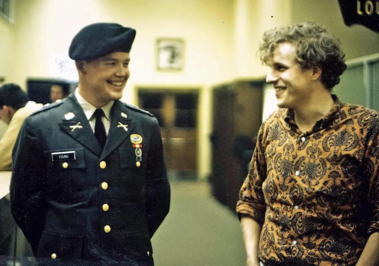 Two men smiling, one in military uniform.