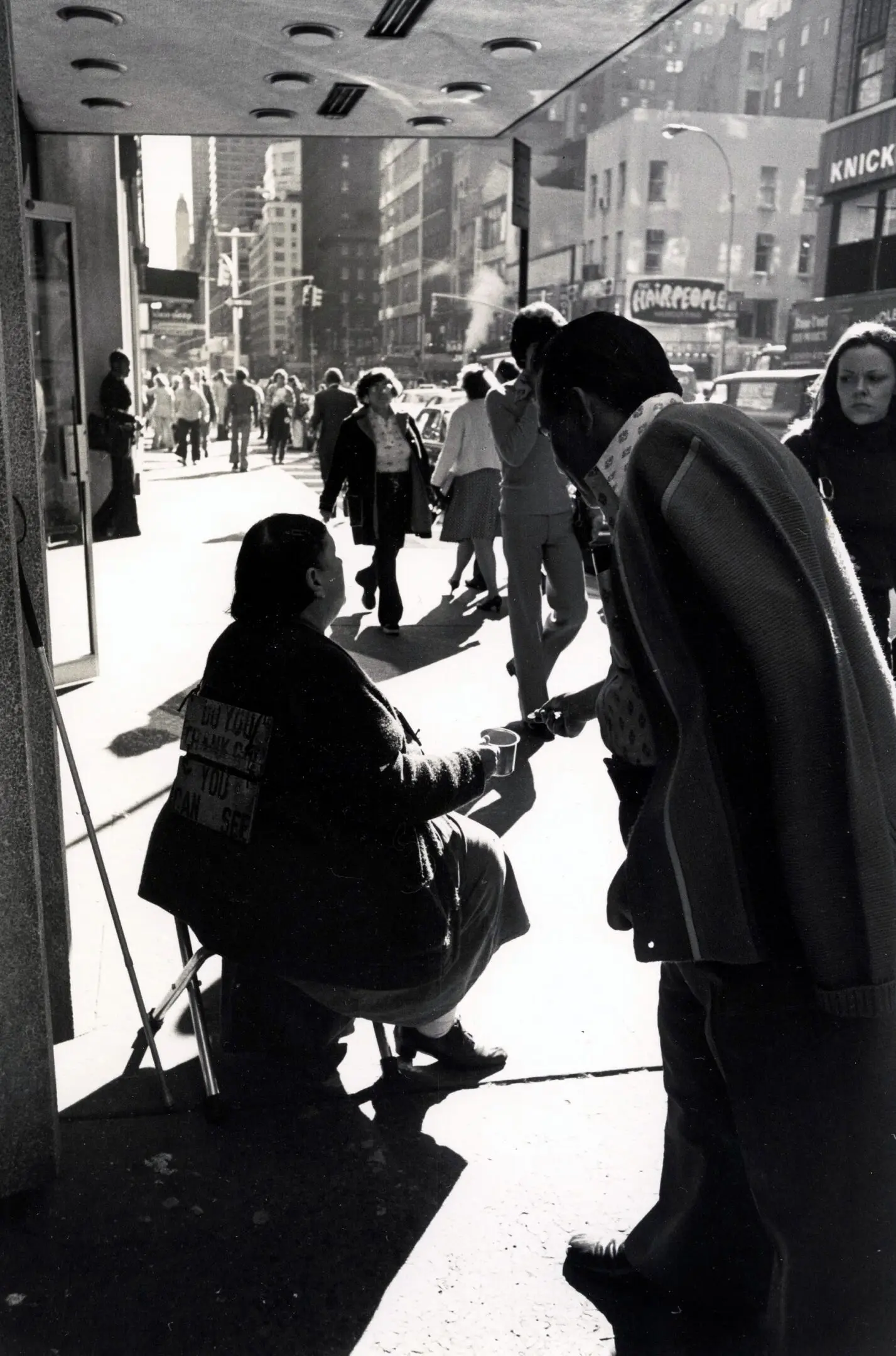 Street scene with people walking and interacting.
