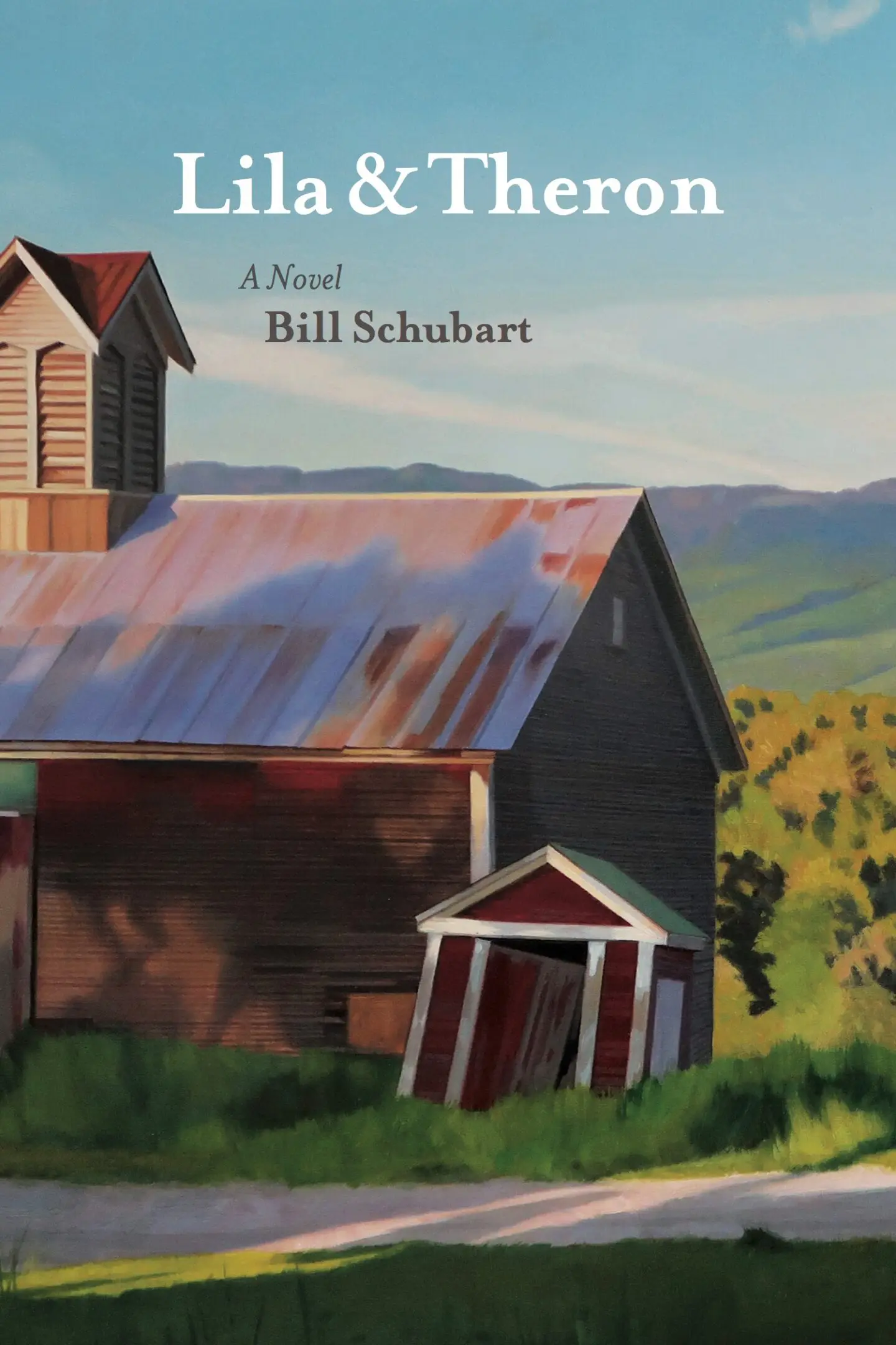 Rustic barn with mountains in background.