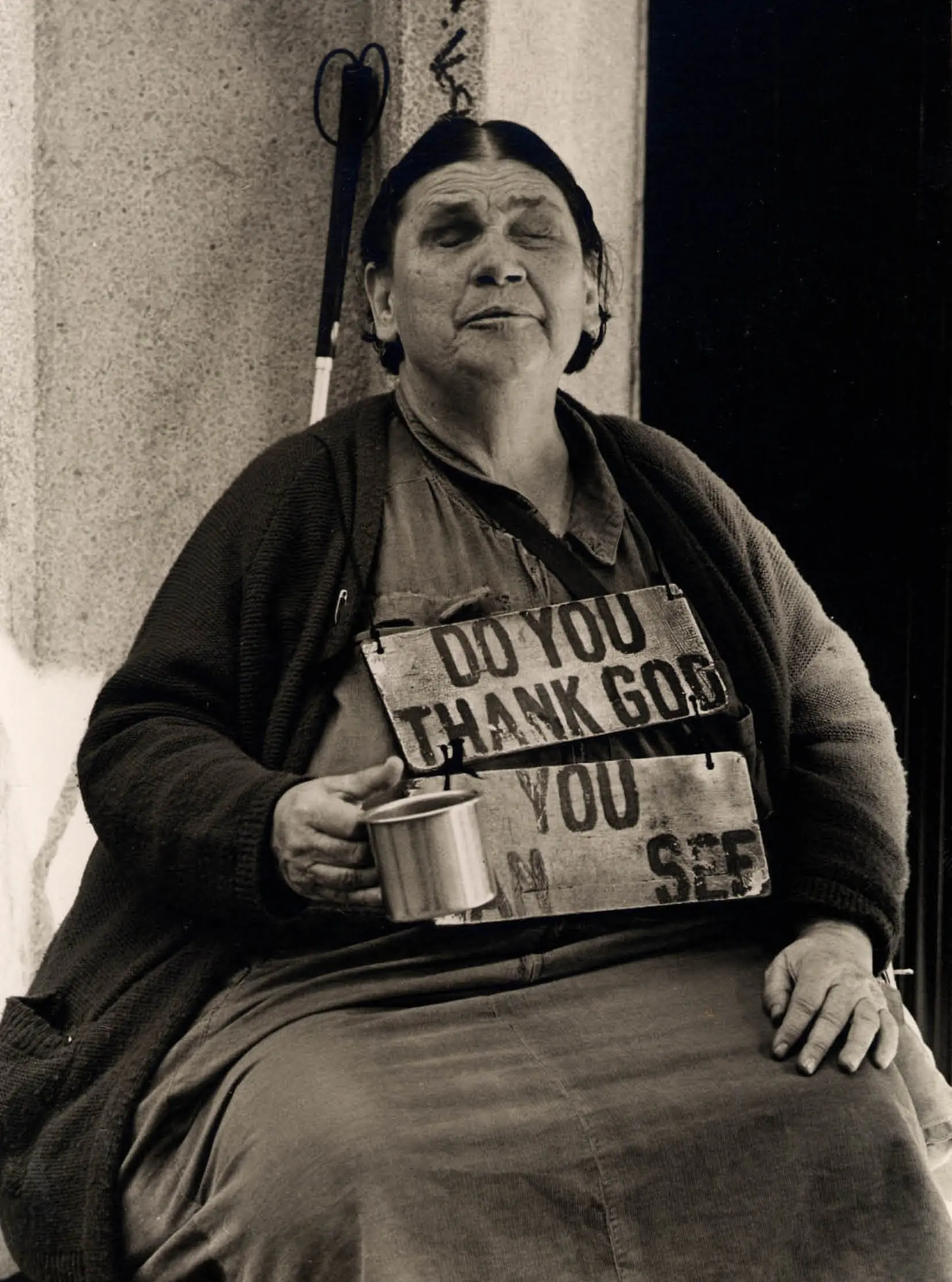 Woman holding cup with sign on chest.