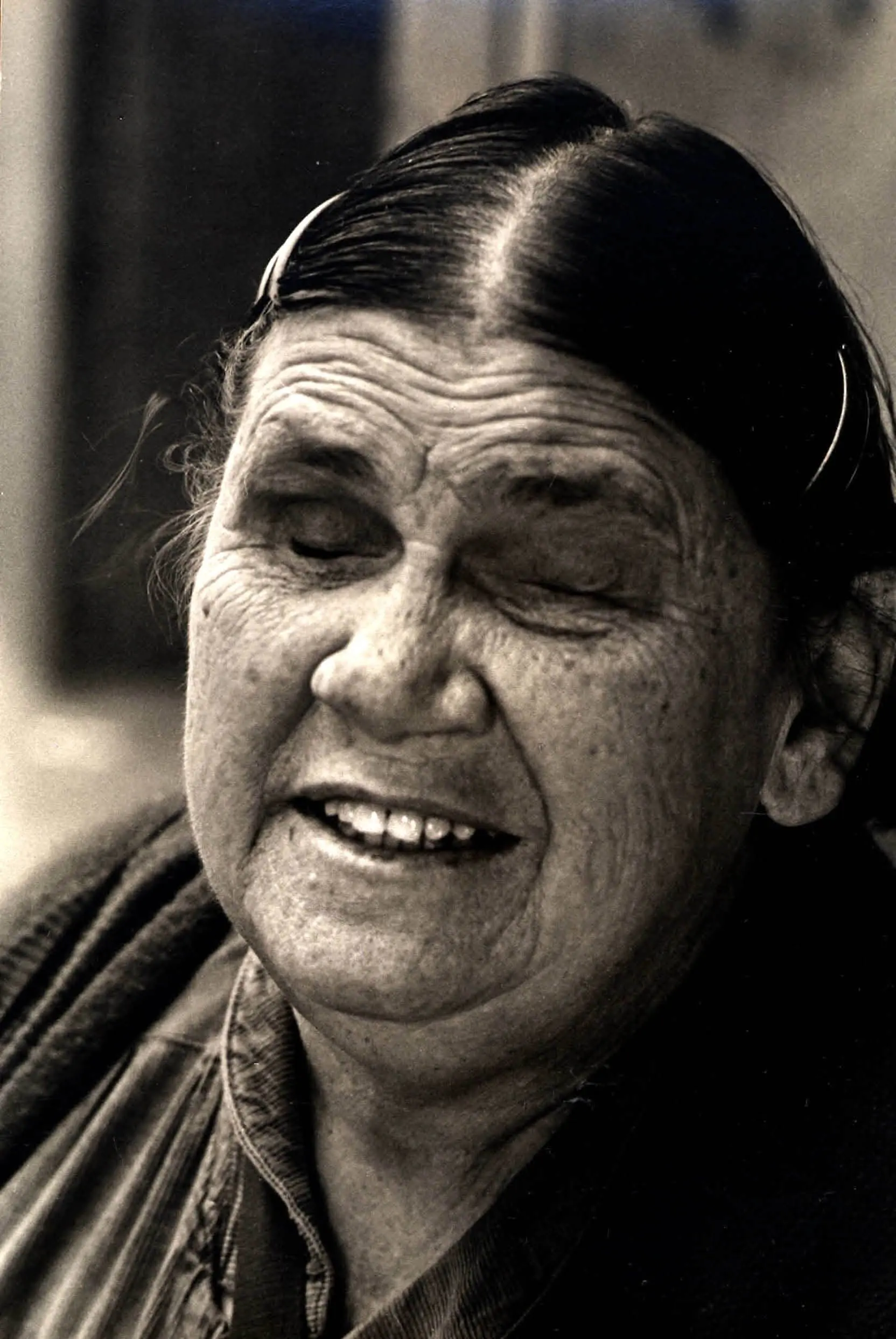 Smiling elderly woman with eyes closed.