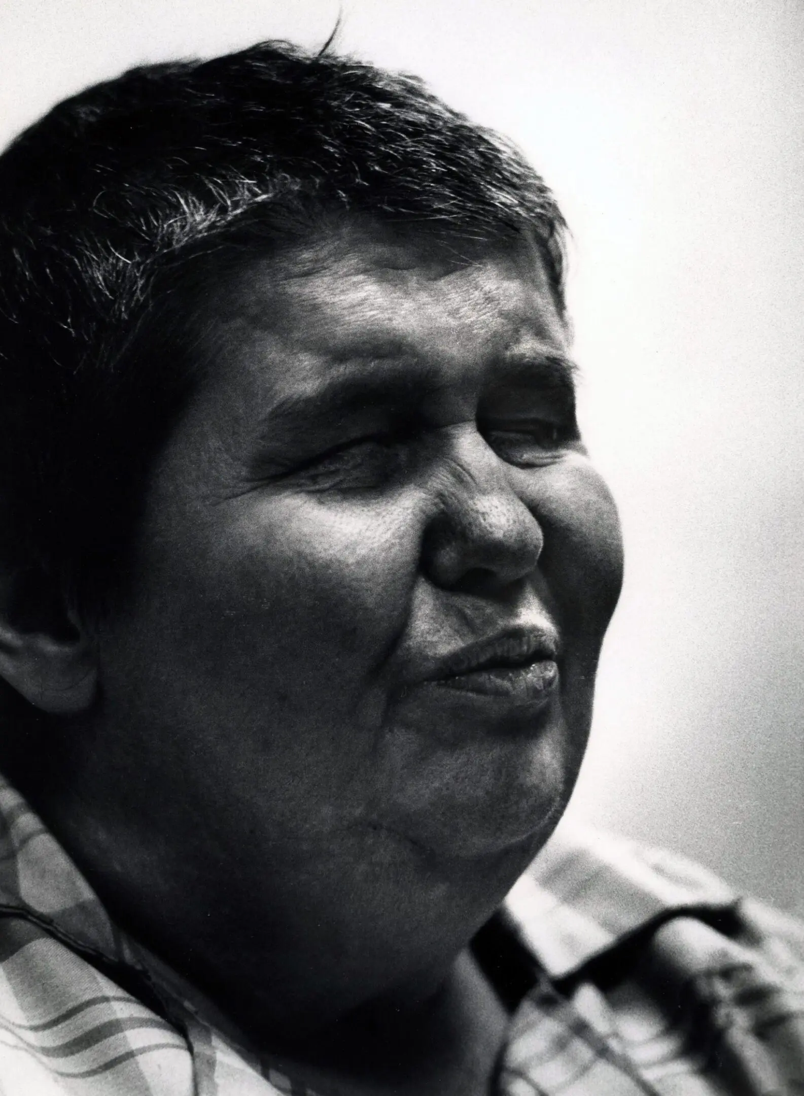Smiling person with eyes closed, black and white.