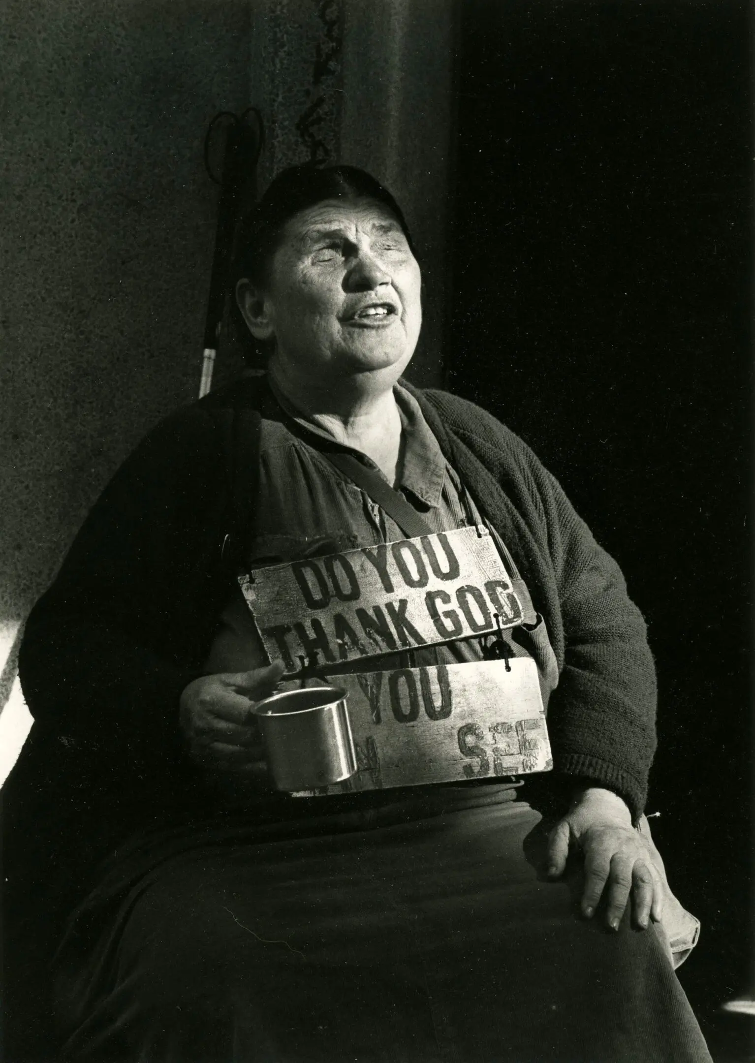 Woman holding mug wearing a signboard.