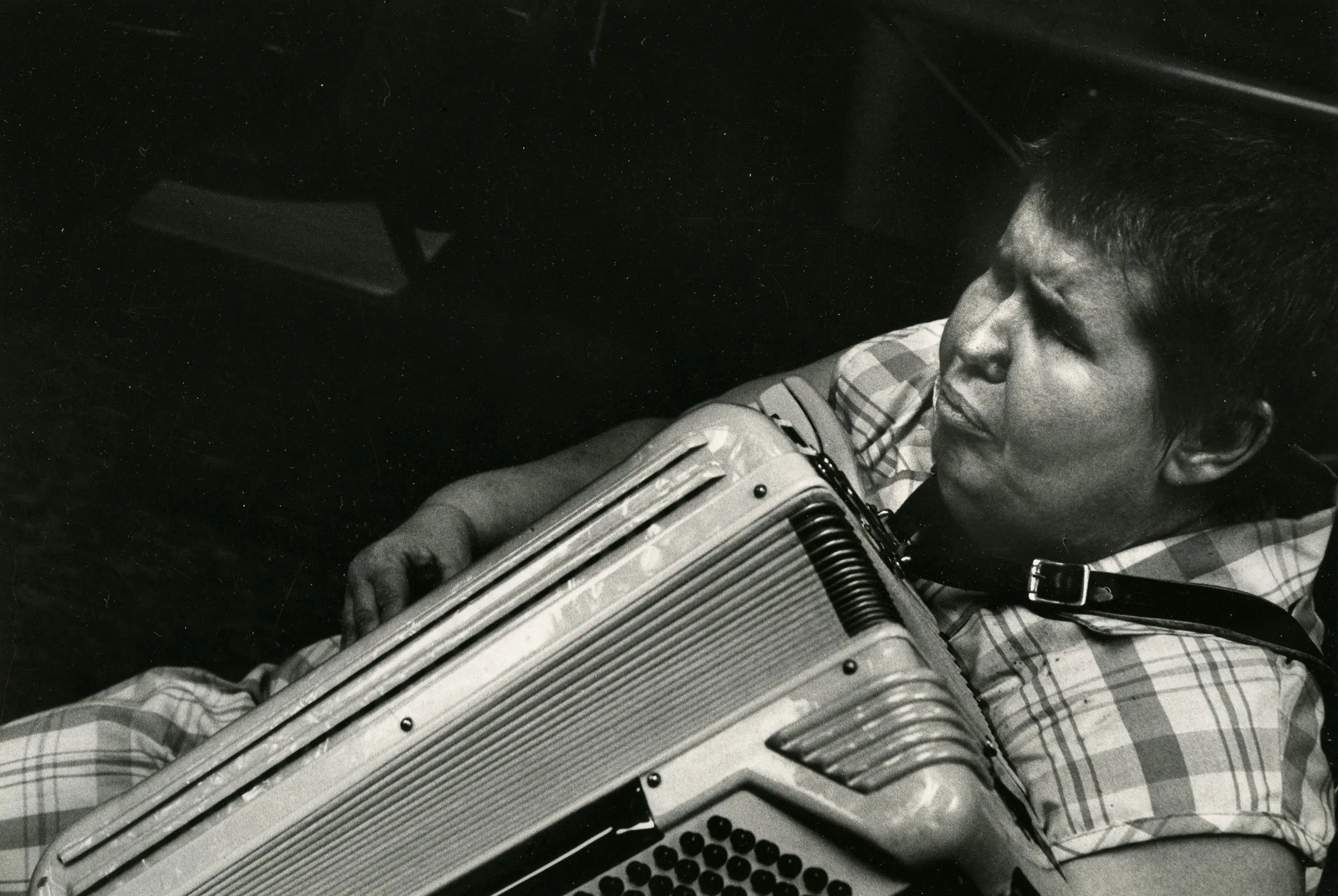 Person playing accordion in black and white.