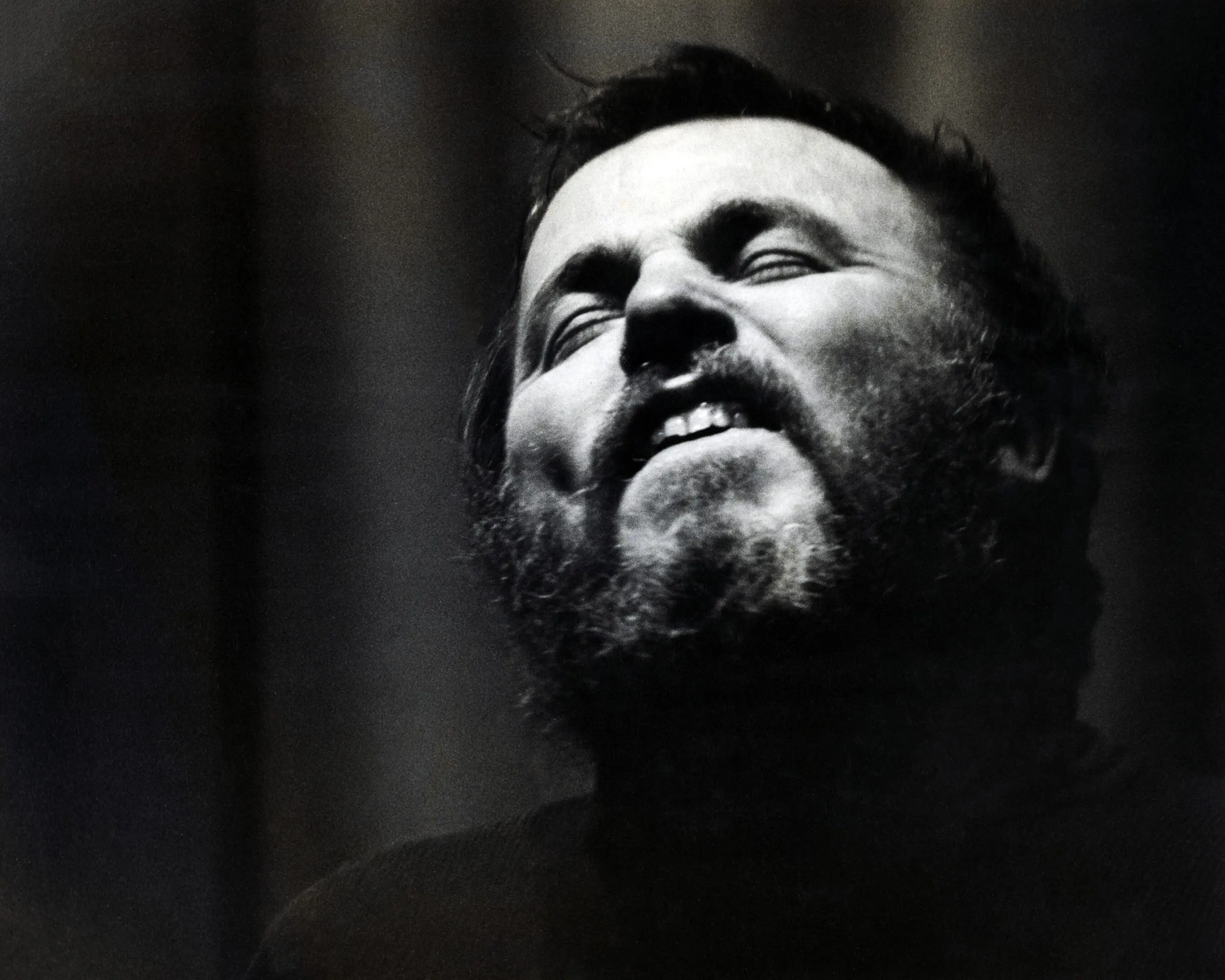 Man passionately singing with eyes closed.