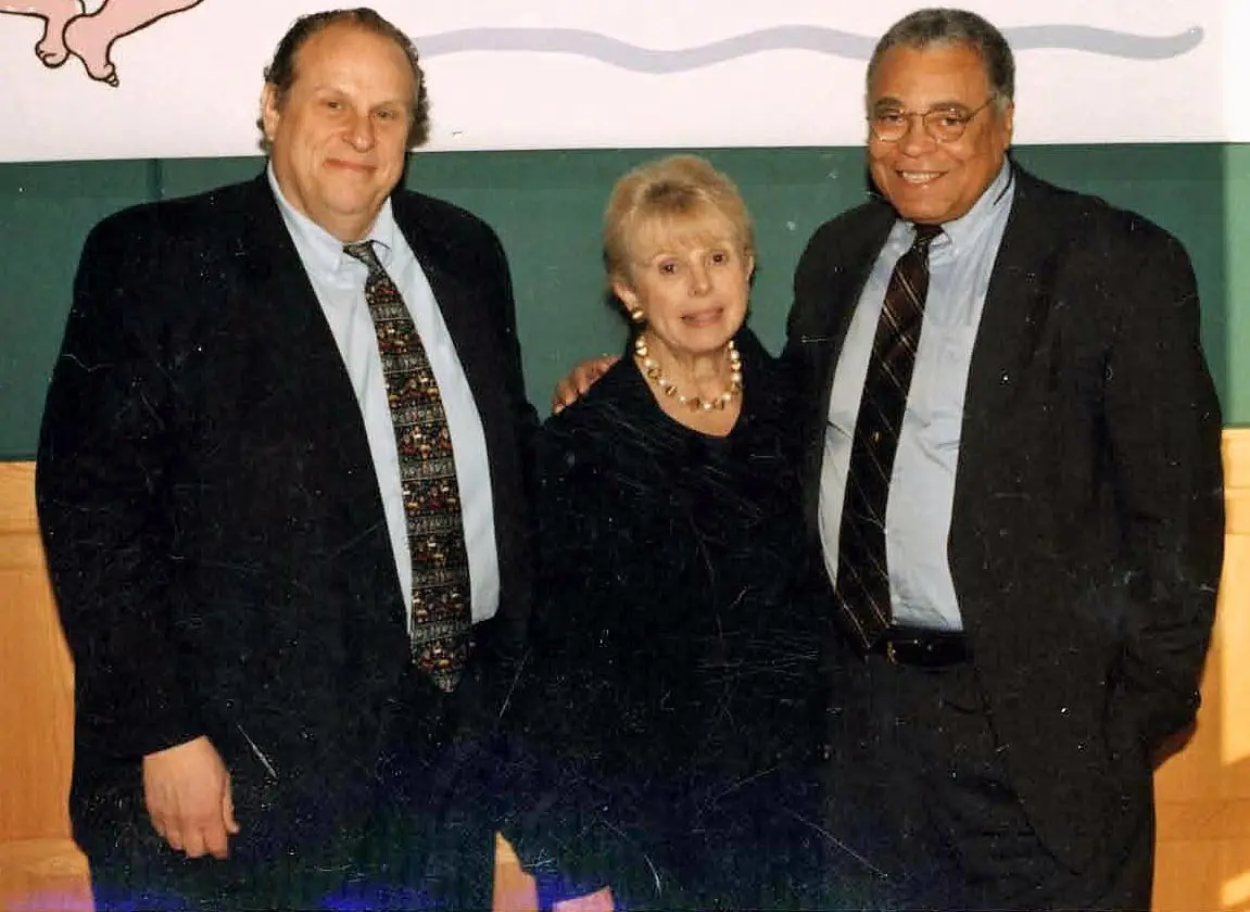 Three people posing in formal attire.