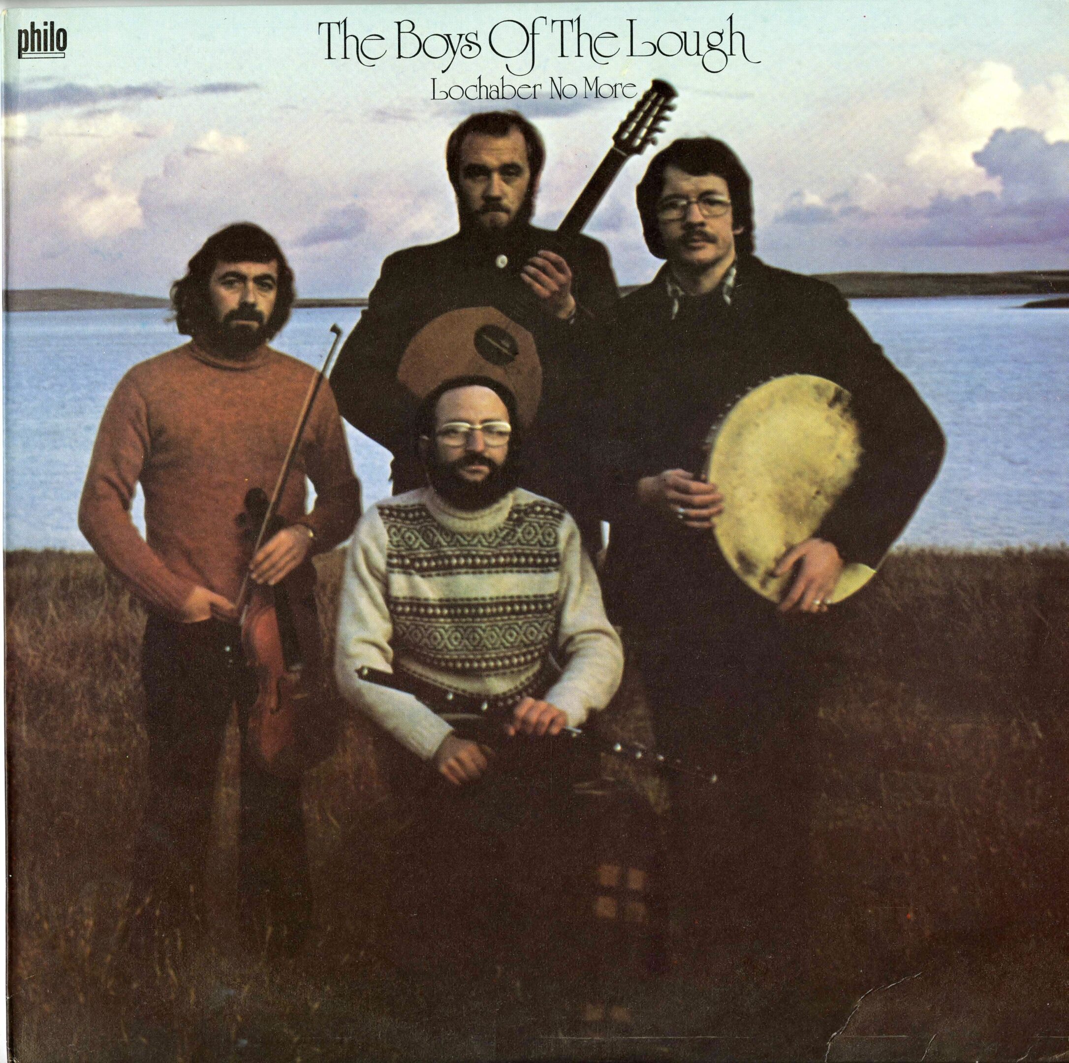 Four men posing with musical instruments outdoors.