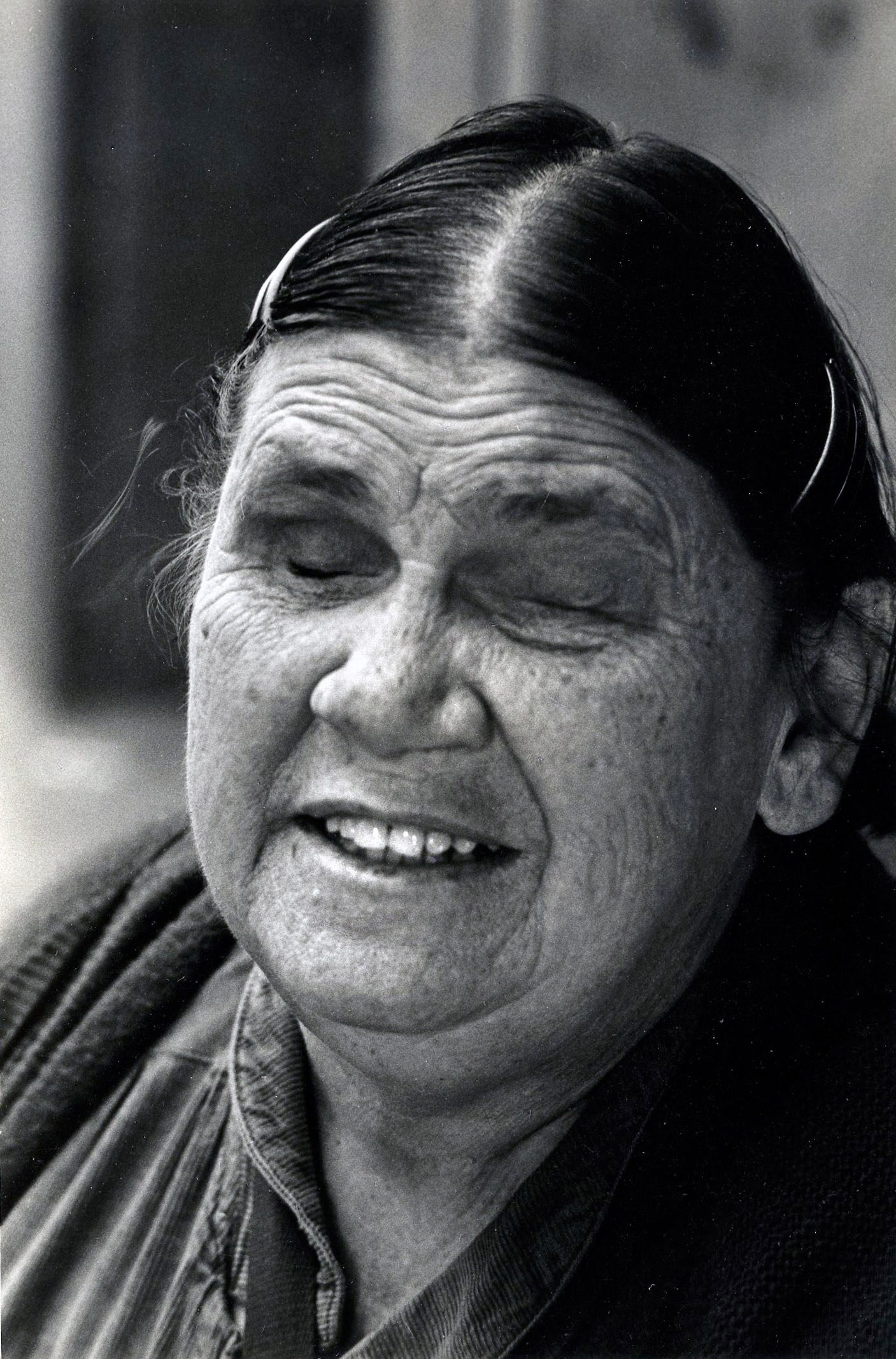 Smiling elderly woman with closed eyes.
