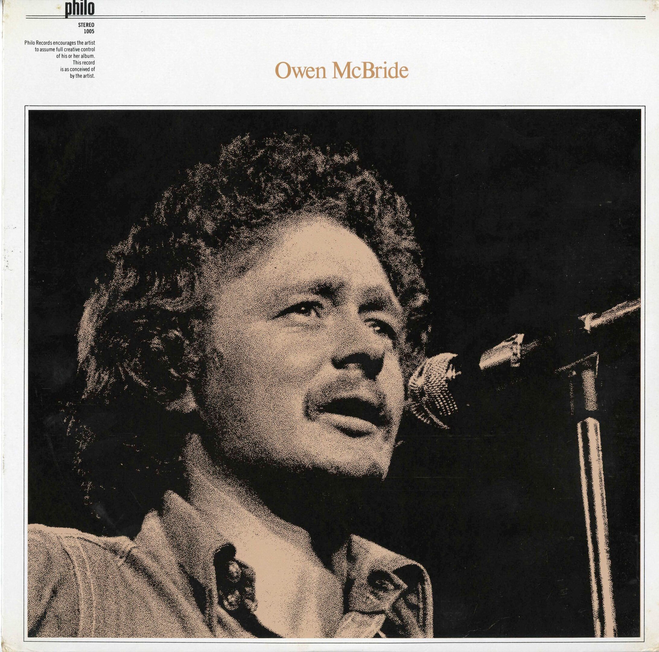 Man singing into a microphone on stage.