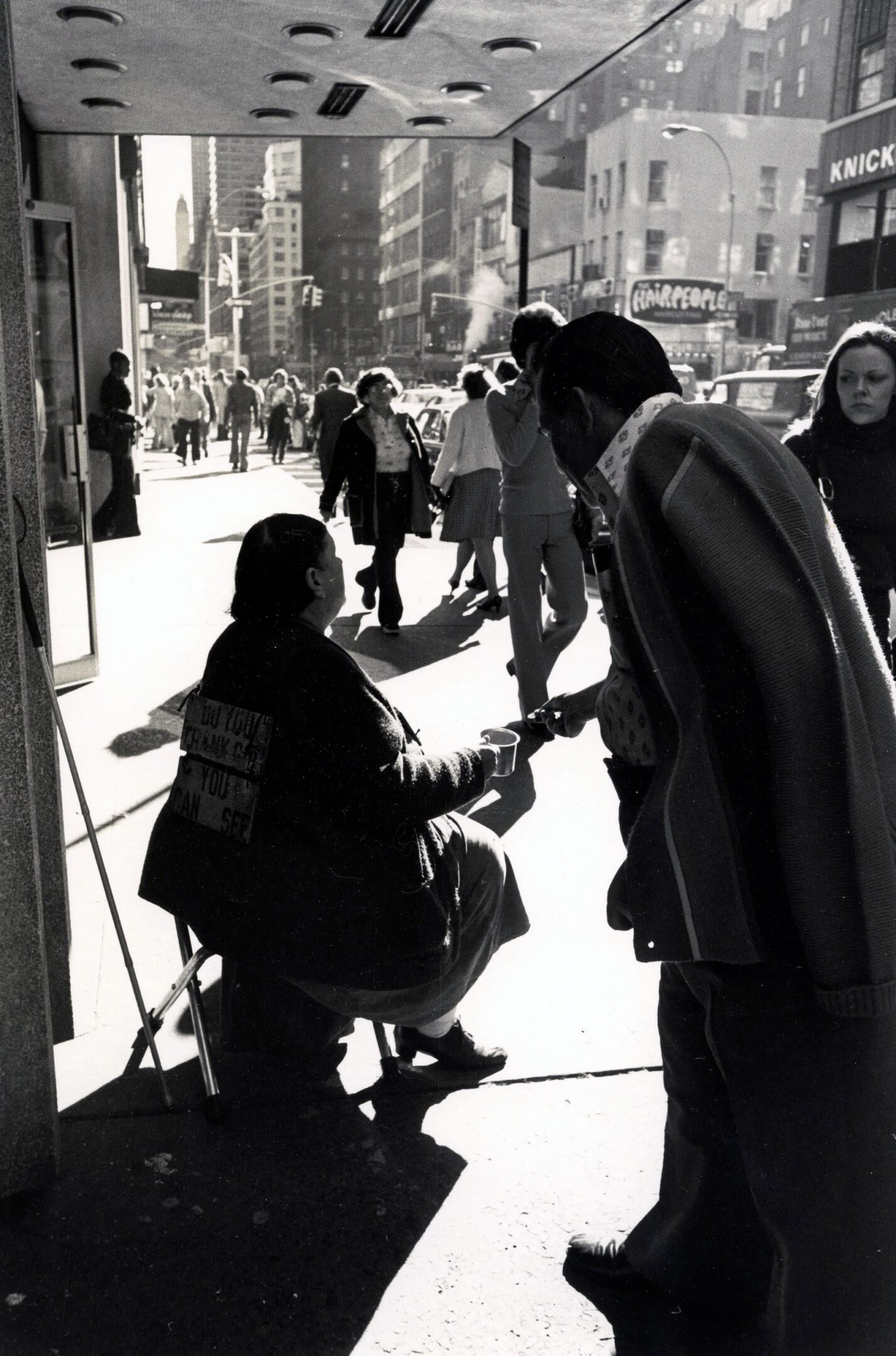 Street scene with people walking and interacting.