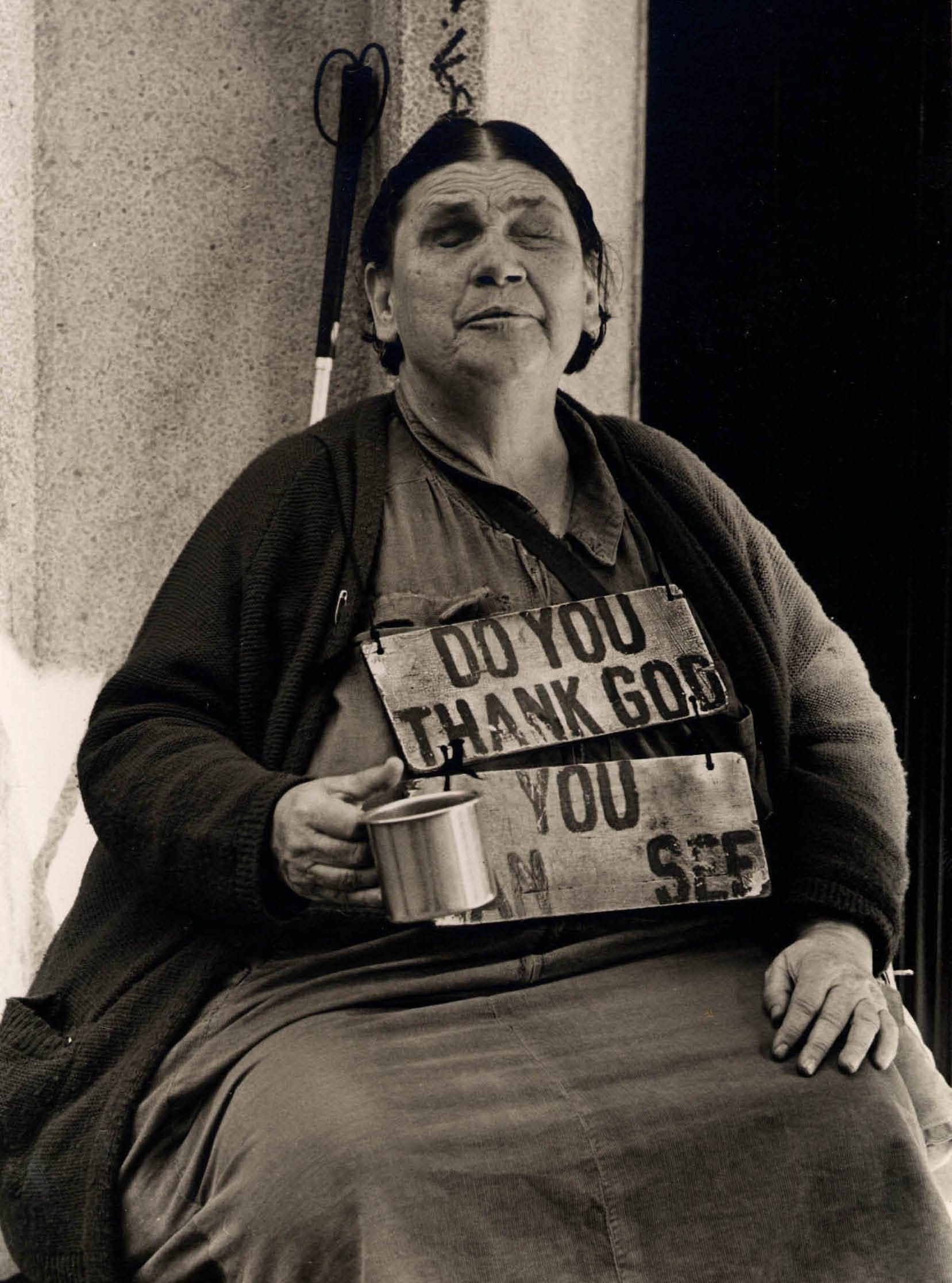Woman holding cup with sign on chest.