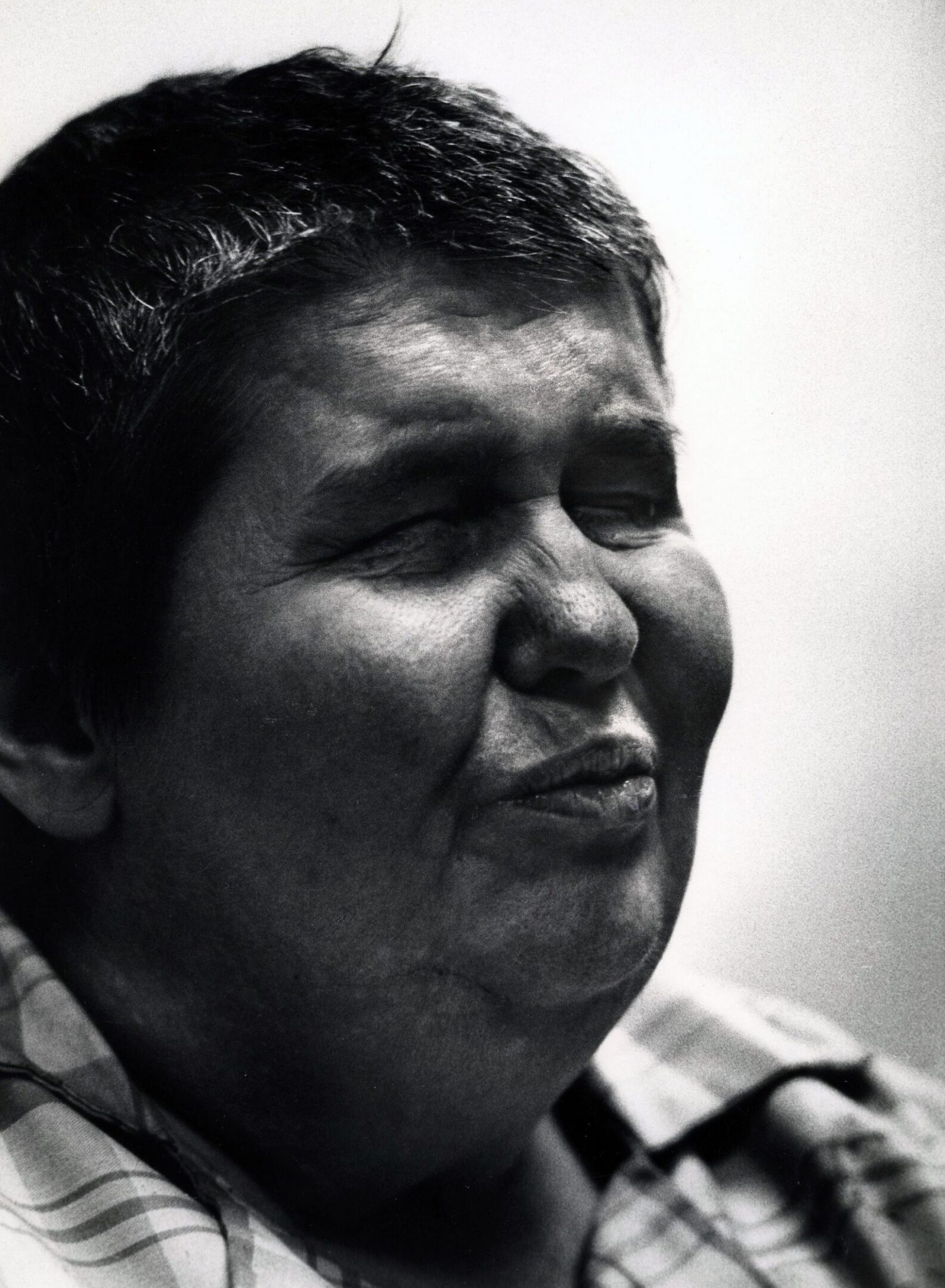 Smiling person with eyes closed, black and white.