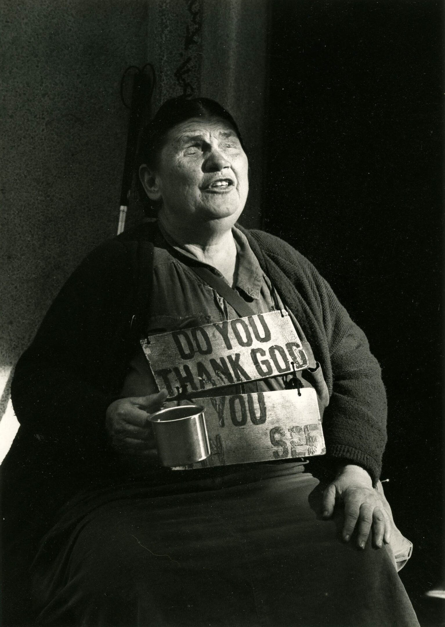 Woman holding mug wearing a signboard.