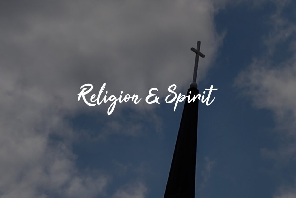 Church steeple under cloudy blue sky.